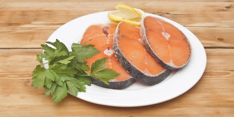 Raw salmon steak on white dish