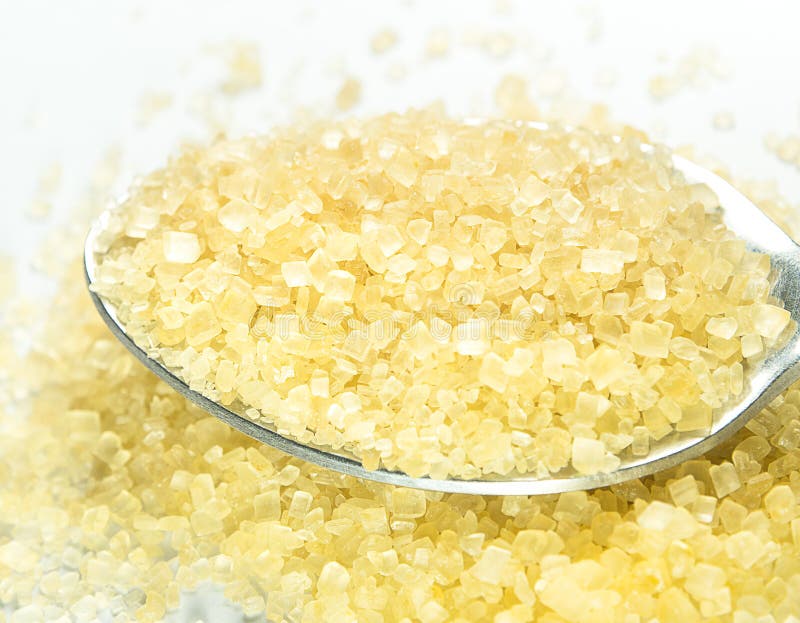 Raw Sugar Crystals on Wooden Spoon. Isolate on White Background. Stock