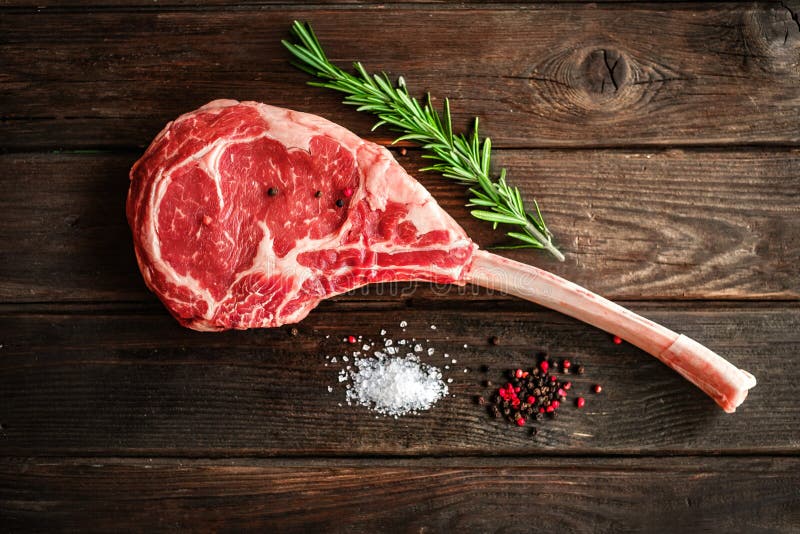 raw tomahawk steak wooden background spices grilling 141318401