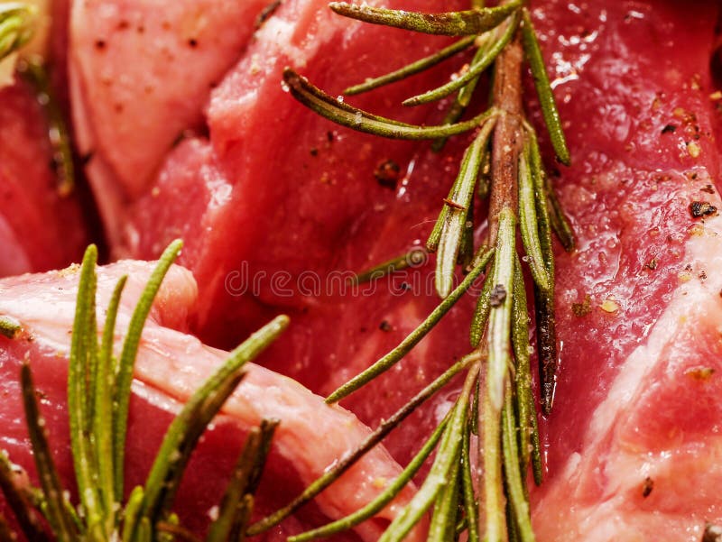 Raw uncooked beef marinated with olive oil and rosemary, close up royalty free stock photography Raw uncooked beef marinated with olive oil and rosemary, close up royalty free stock photography
