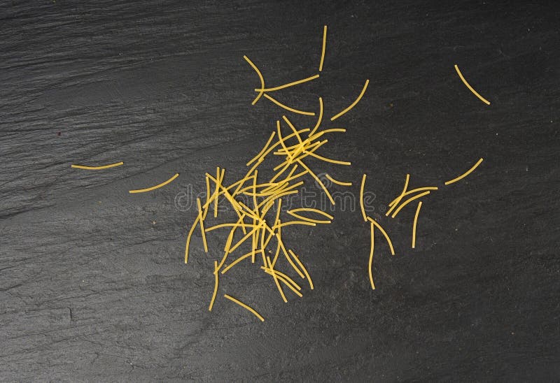 Raw vermicelli, gold soup pasta, small scattered homemade noodles, thin macaroni royalty free stock photo