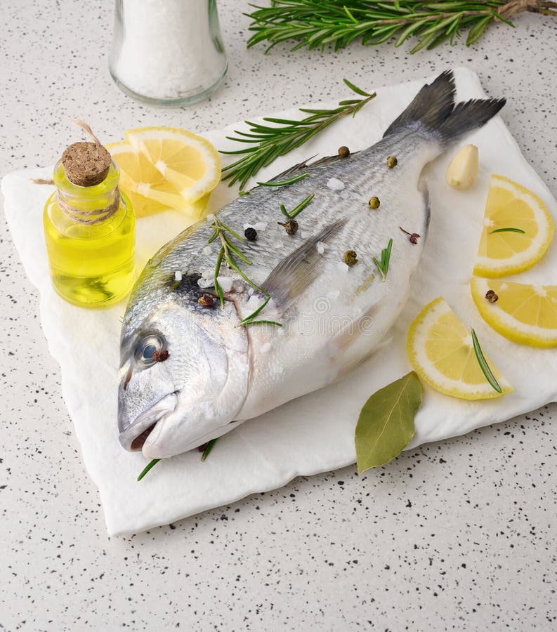 Raw Whole Dorado Fish on White Board and Spices for Cooking, Top View