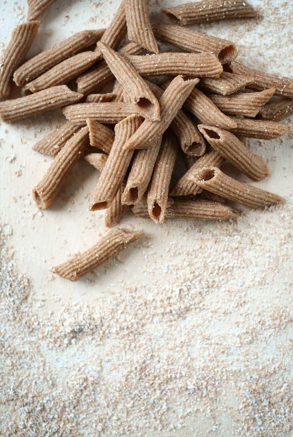 Raw Whole Grain Pasta Homemade on the Table with Flour Stock Photo