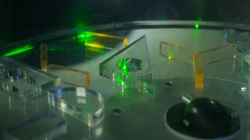 Ray of green laser lights through different transparent figures