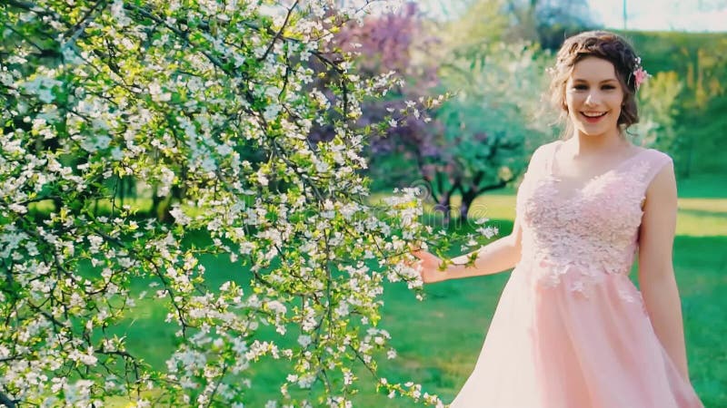 Rayons de soleil. Jeune femme heureuse marche dans la nature de printemps jardin sourire à visage banque de vidéos
