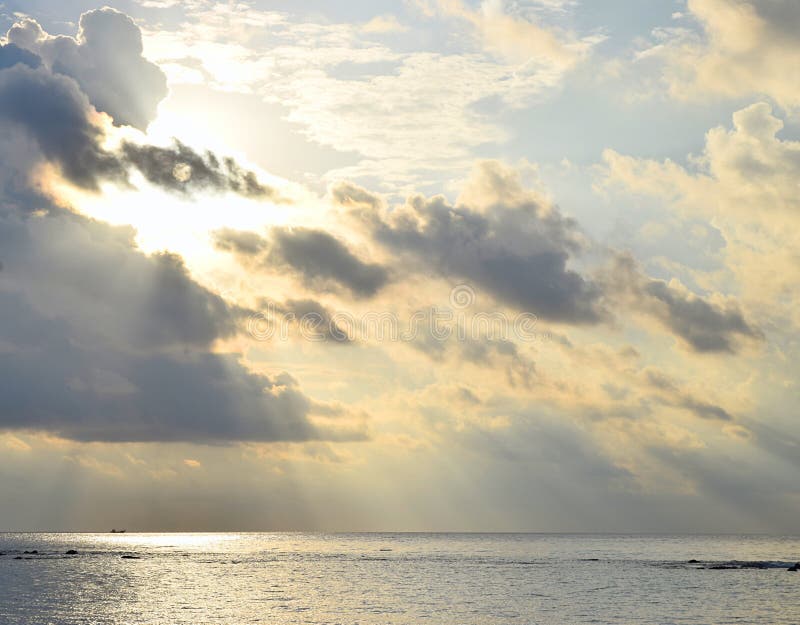 Rayons de soleil lumineux de Sun jaune d'or derri?re les nuages fonc?s et r?partir toujours l'eau de mer - descente des b?n?dicti photographie stock libre de droits Rayons de soleil lumineux de Sun jaune d'or derri?re les nuages fonc?s et r?partir toujours l'eau de mer - descente des b?n?dicti photographie stock libre de droits
