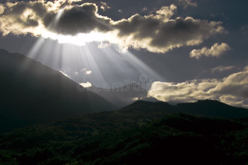 Sun rays and clouds over the mountains landscape. Sun rays and clouds over the mountains landscape