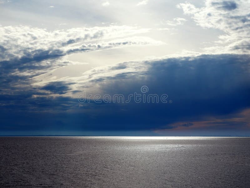 Rayos del sol a través de las nubes de tormenta sobre el mar imagen de archivo libre de regalías Rayos del sol a través de las nubes de tormenta sobre el mar imagen de archivo libre de regalías