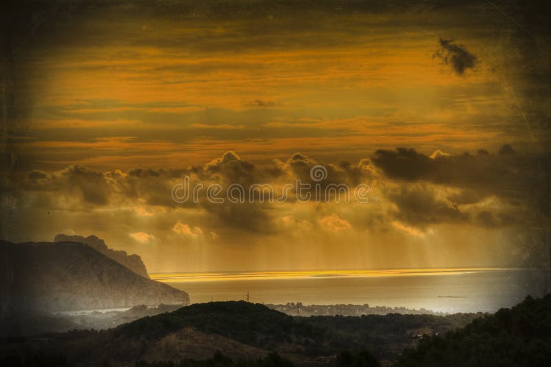 Rayos de la luz sobre el amanecer a través de nubes a reflexivo Océano.