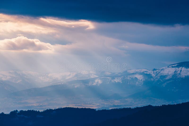 Rays of light pass through the clouds, mountain landscape