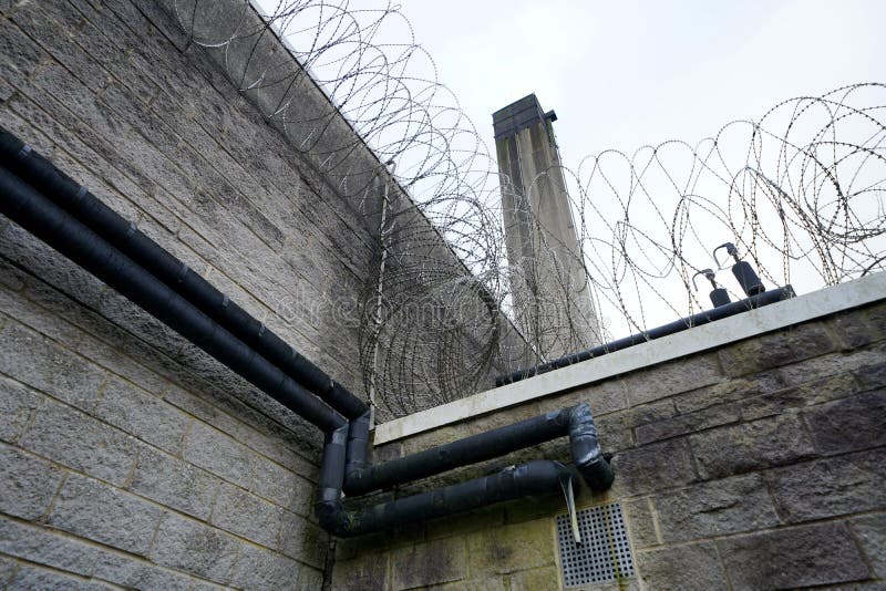 Razor wire coils on prison building royalty free stock image