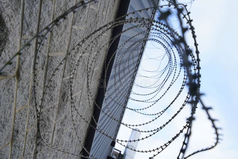 Razor wire coils on prison building royalty free stock photo