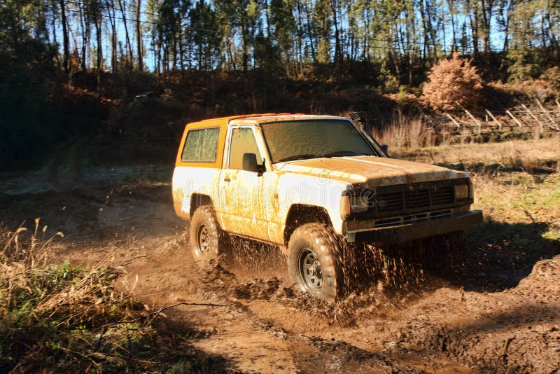 A jeep speeding along river and mud. Intentional motion blur. A jeep speeding along river and mud. Intentional motion blur.