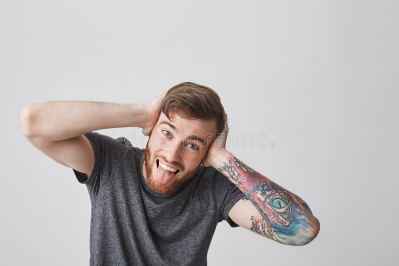 We`re All Mad Here. Portrait of Good-looking Funny European Man with Beard  and Tattooed Arm Looking in Camera with Crazy Stock Photo - Image of  beauty, copyspace: 103247772
