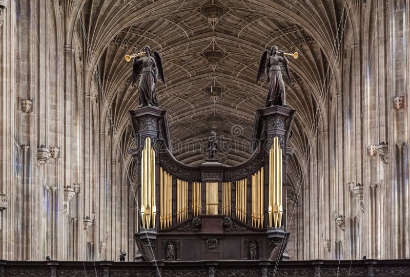The pipe organ with two archangels playing trumpets inside Kings College Chapel in Cambridge, England. The pipe organ with two archangels playing trumpets inside Kings College Chapel in Cambridge, England