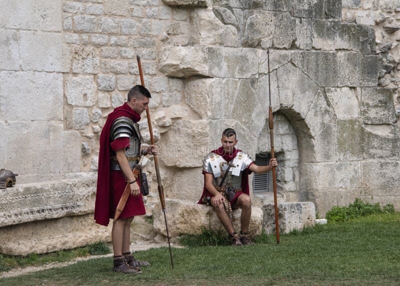 Re-enactors одетые как римские легионеры, ждут для того чтобы представить с туристами на воротах к дворцу Diocletian стоковые фотографии rf Re-enactors одетые как римские легионеры, ждут для того чтобы представить с туристами на воротах к дворцу Diocletian стоковые фотографии rf
