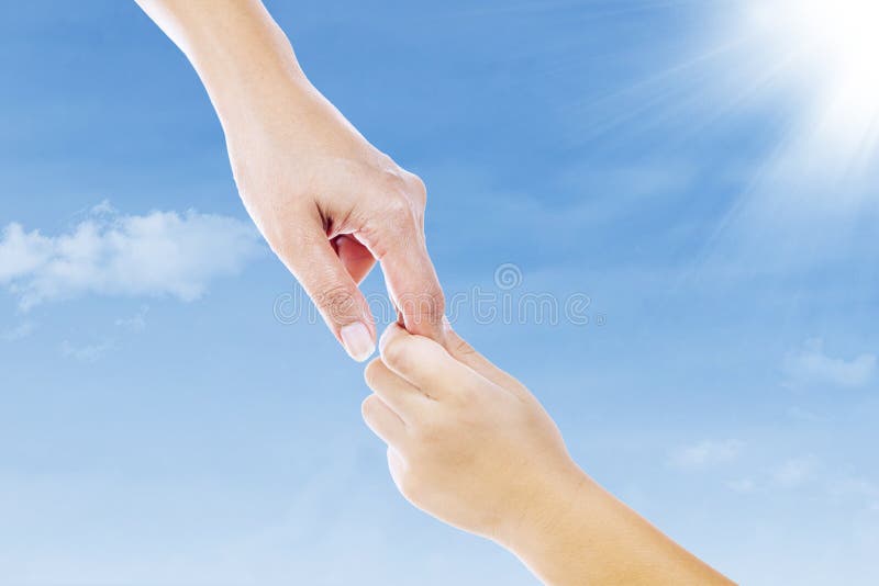 A hand reaching out to the sky. Picture of a mother hand holding her sons hand