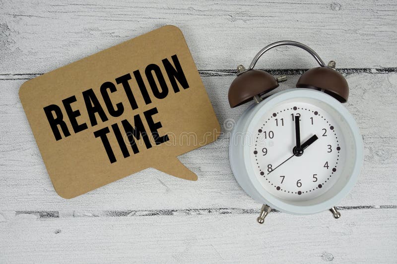 Reaction Time text with alarm clock on wooden background royalty free stock image