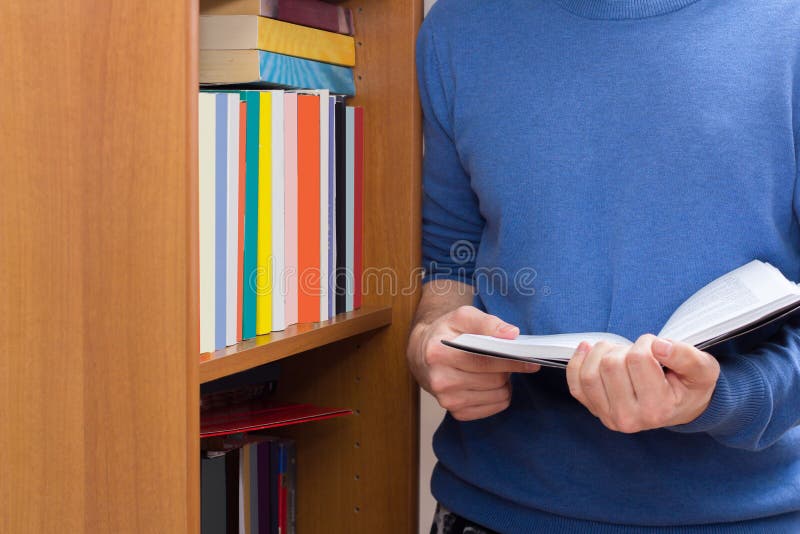 Reading book near bookcase stock photo. Image of holding 85210996