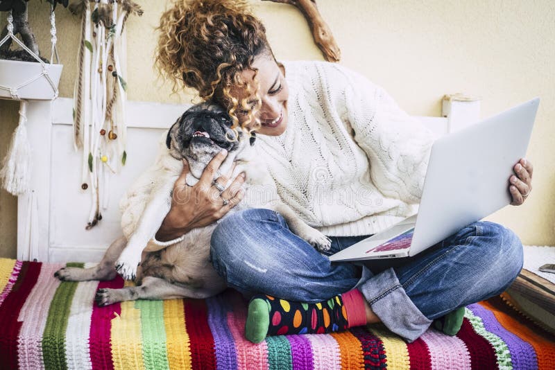 Real best friends cheerful woman working at laptop on the terrace at home while hug her best love and friends smiling dog pug stock photos Real best friends cheerful woman working at laptop on the terrace at home while hug her best love and friends smiling dog pug stock photos