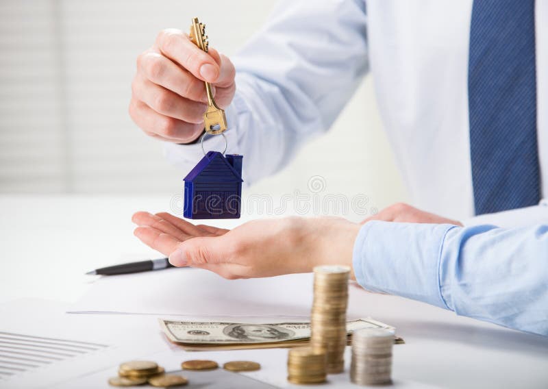 Real Estate Agent Giving Keys To the Customer Over the Table Stock
