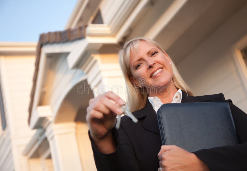 Female Real Estate Agent Handing Over Keys in Front of Beautiful House. Female Real Estate Agent Handing Over Keys in Front of Beautiful House.