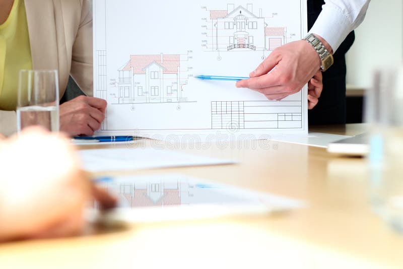 Real-estate agent showing a house plans with a businessman. stock image Real-estate agent showing a house plans with a businessman. stock image