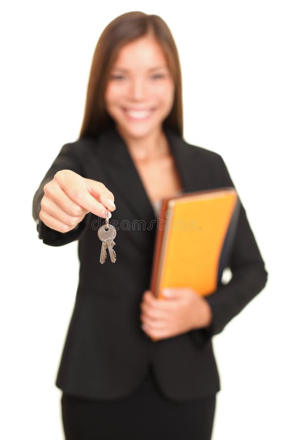 Real estate agent giving keys. Young realtor smiling handing over house keys to the new house owner, focus on keys. Isolated on white background. Real estate agent giving keys. Young realtor smiling handing over house keys to the new house owner, focus on keys. Isolated on white background.