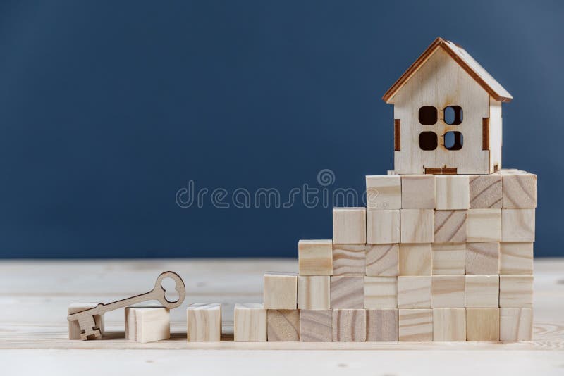 Real estate concept. Small toy wooden house with keys