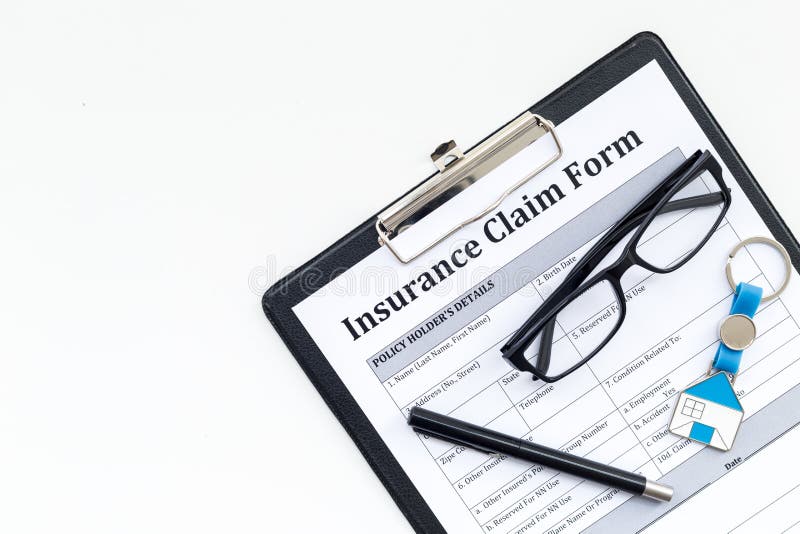 Real estate insurance. Insurance claim form near house keychain on white background top view copy space stock photography Real estate insurance. Insurance claim form near house keychain on white background top view copy space stock photography