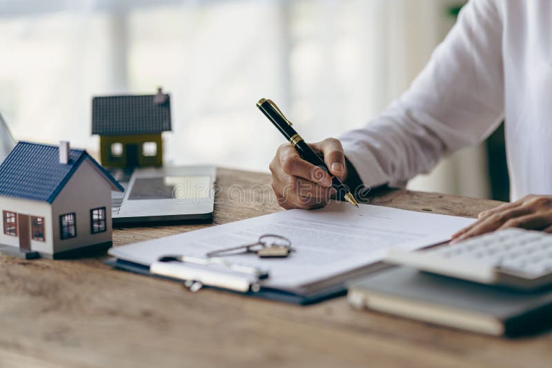Real Estate Office, Home Sales Agent Sitting at Desk with Contract