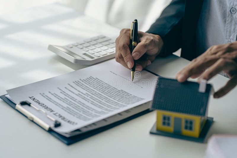 Real Estate Office, Home Sales Agent Sitting at Desk with Contract