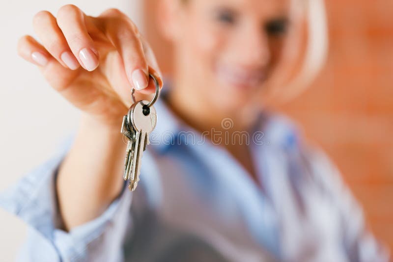 Realtor is giving the keys to an apartment to some clients – focus on the keys. Realtor is giving the keys to an apartment to some clients – focus on the keys