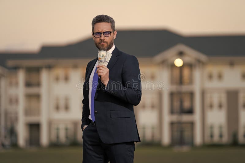 Realtor ofrece nuevo hogar. Ingeniero profesional. Exitoso agente inmobiliario en traje con dinero. Casa para fotos de archivo libres de regalías