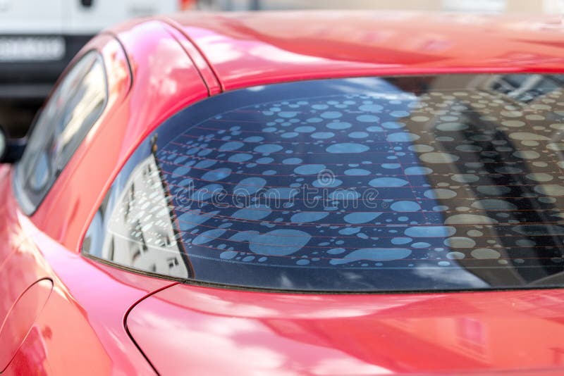 Rear car window with old adhesive defective dark sunproof tint film in air bubbles. Mistake wrong badly installation