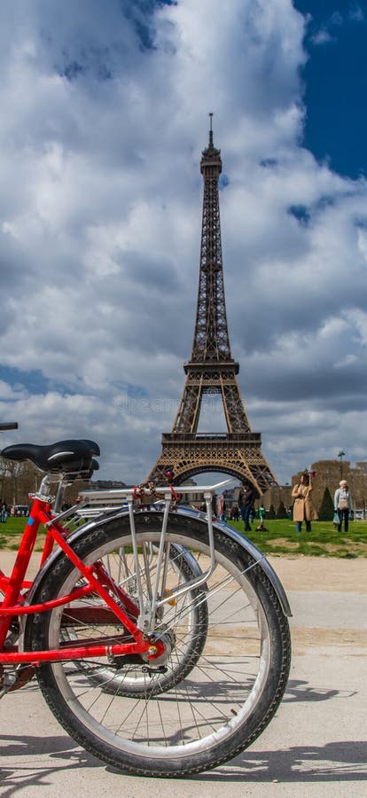 Rear red bicycle wheel over Eiffel tower on background in Paris