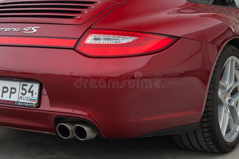 Rear taillamp and exhaust view of car Porsche 911 Carrera 4s with dark gray interior in excellent condition in a parking against stock image Rear taillamp and exhaust view of car Porsche 911 Carrera 4s with dark gray interior in excellent condition in a parking against stock image