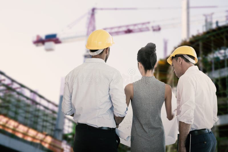 Composite image of rear view of architects discussing over blueprint royalty free stock image Composite image of rear view of architects discussing over blueprint royalty free stock image