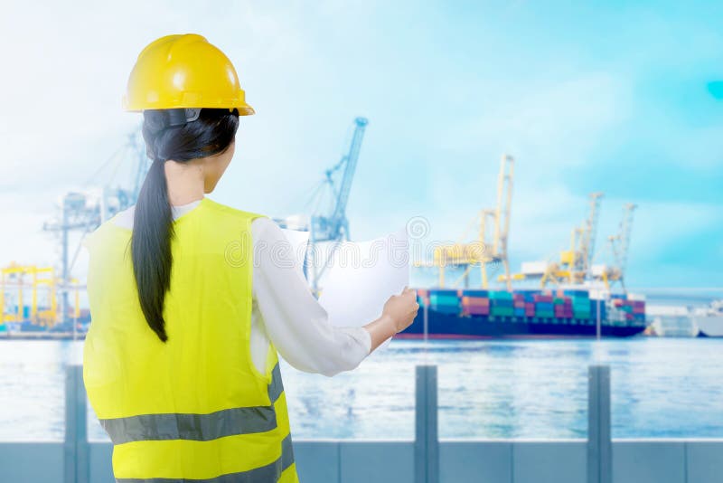 Rear view of asian worker woman with yellow hard hat looking at paperwork on the office royalty free stock photo Rear view of asian worker woman with yellow hard hat looking at paperwork on the office royalty free stock photo