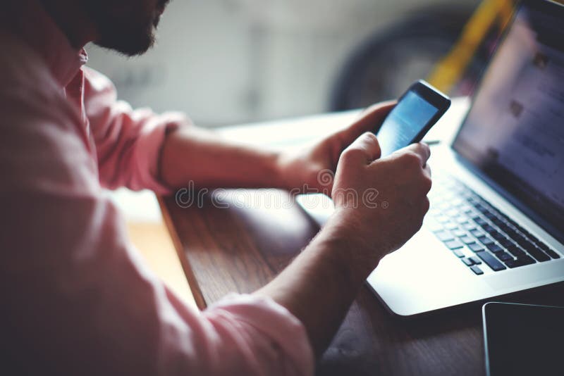 Rear view of business man hands busy using cell phone at office desk stock photos