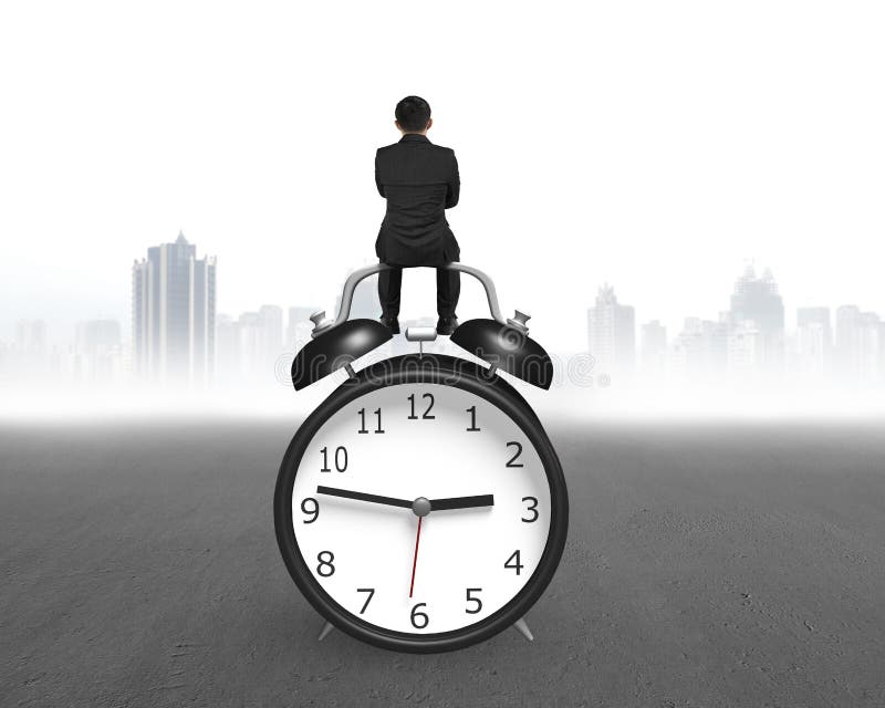 Rear view businessman sitting on alarm clock stock photography