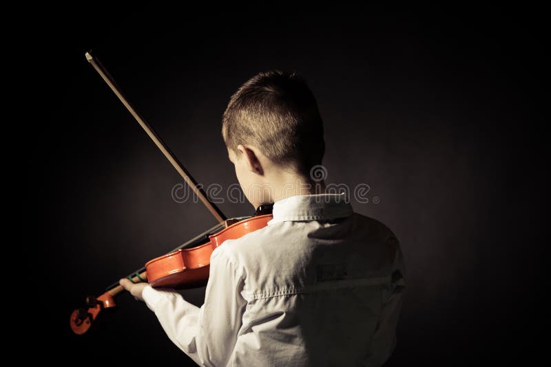 Rear view of child playing violin in darkened room royalty free stock photography Rear view of child playing violin in darkened room royalty free stock photography