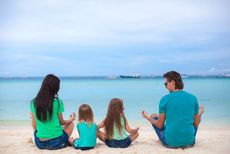 Rear view of a family of four sitting in the lotus royalty free stock image Rear view of a family of four sitting in the lotus royalty free stock image