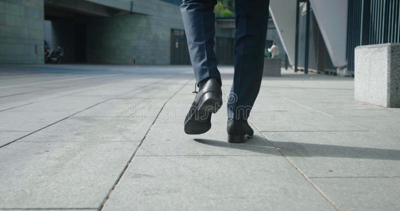 Rear view feet of businessman going to work. Back view of confident man businessman in leather shoes and formal suit