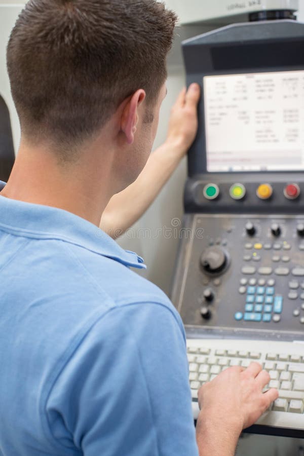Rear View Of Male Engineer Operating CNC Machine In Factory royalty free stock photo Rear View Of Male Engineer Operating CNC Machine In Factory royalty free stock photo