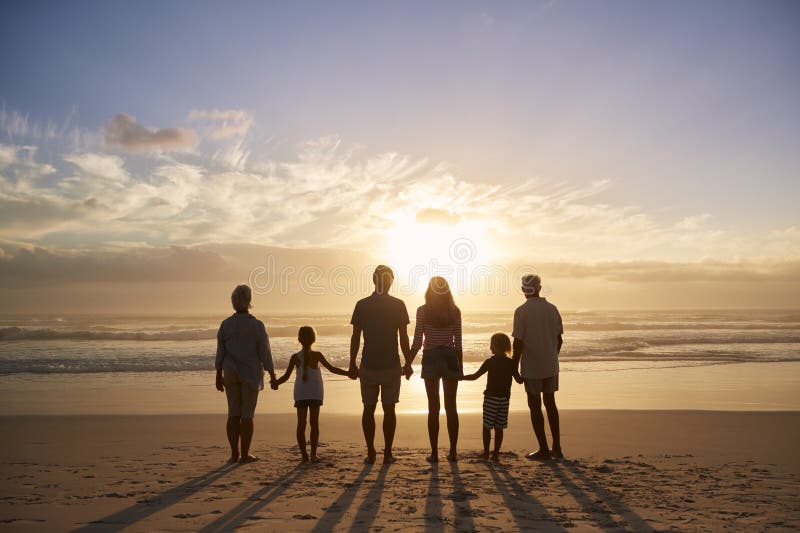 Rear View Of Multi Generation Family Silhouetted On Beach royalty free stock photo