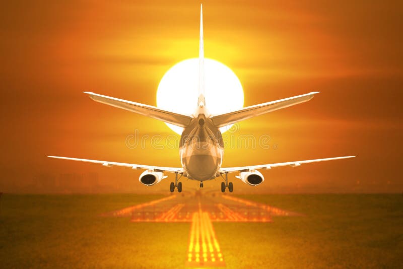 Rear View Passenger Aircraft Takeoff on Runway in Sunset Stock Photo