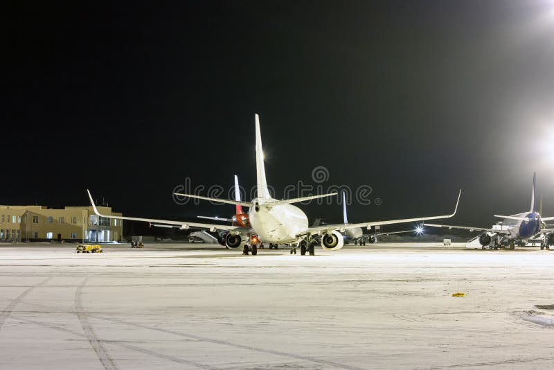 Rear view of the passenger aircrafts on the airport apron at winter night stock images Rear view of the passenger aircrafts on the airport apron at winter night stock images