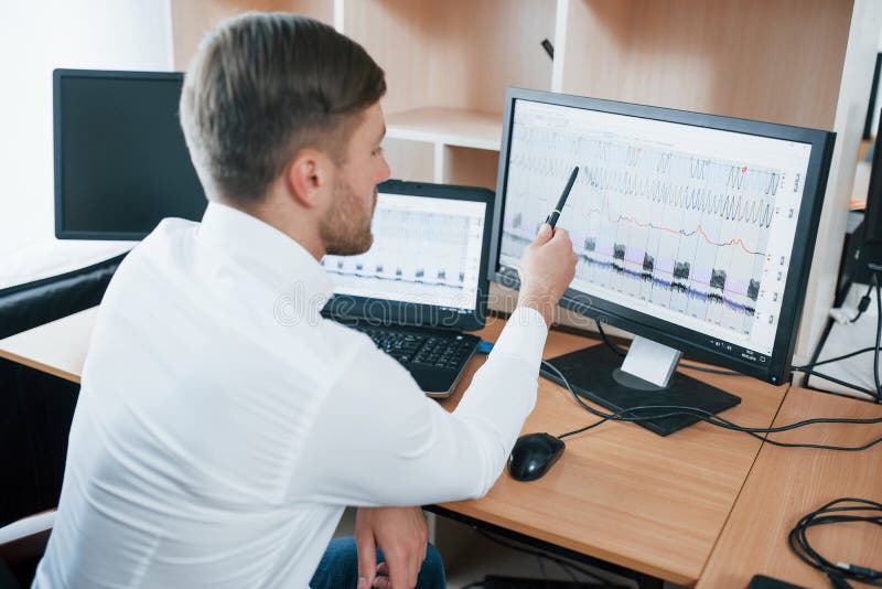 Rear View. Polygraph Examiner Works in the Office with His Lie Detector`s Equipment Stock Image