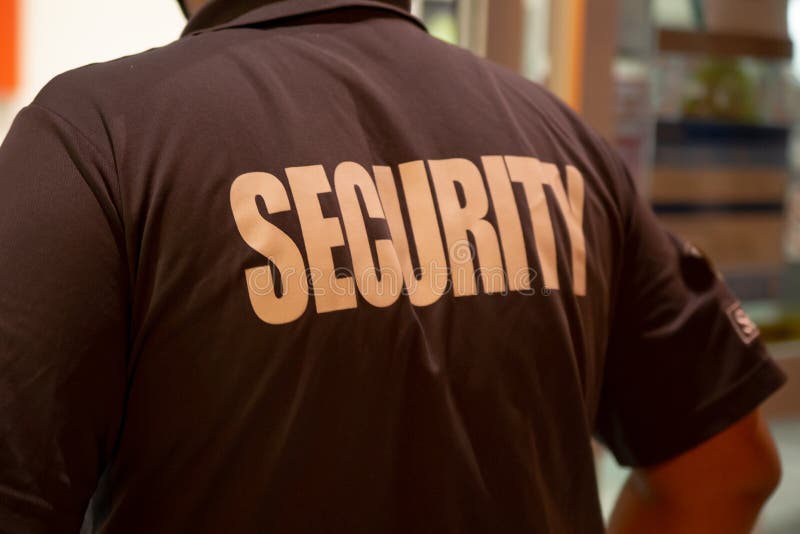 Rear View of Security Guard in Uniform Patrolling in Commercial Mall